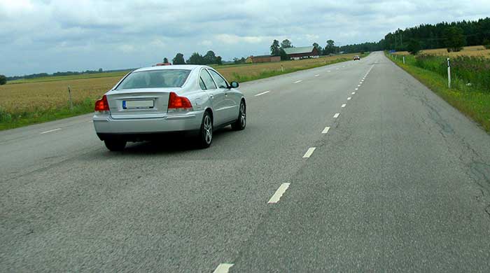 Drive on the hard shoulder to assist the silver car overtaking you.